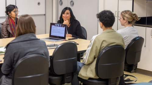 Senior Associate Dean for Education and Academic Affairs Carol Terregino and students sit around a conference room table in the medical school