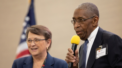 Woman and man speaking into microphone at event