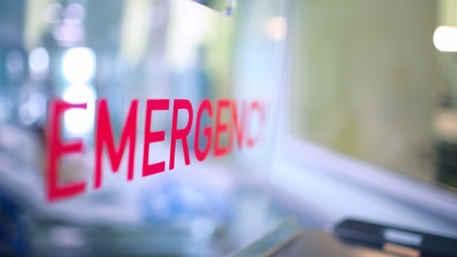 Transparent plastic divider on the reception desk in the hospital admission department with red lettering emergency