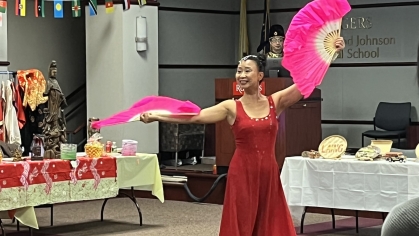 A performer holds bright pink fans during an Expressions of Me event 