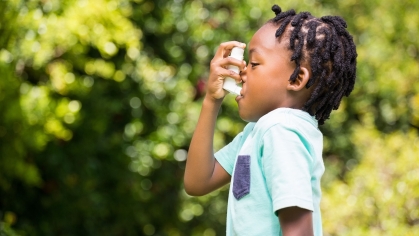 boy uses asthma inhaler