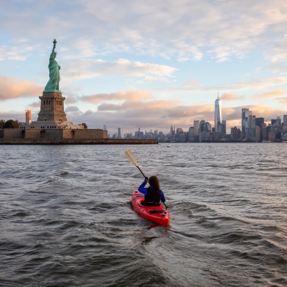 A woman kayaks near the Statue of Liberty