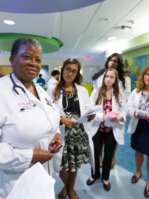 A faculty member provides instruction to medical students in a clinical space