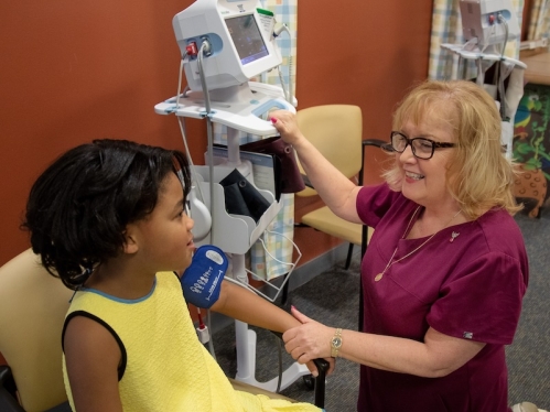 A nurse taking the blood pressure of a child.