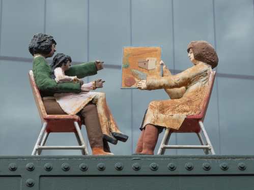 A sculpture depicting a speech therapist working with a child and mother