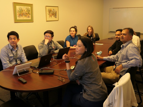 Fellows in the epilepsy fellowship sitting around a conference table with Program Director, Ram Mani MD MSCE