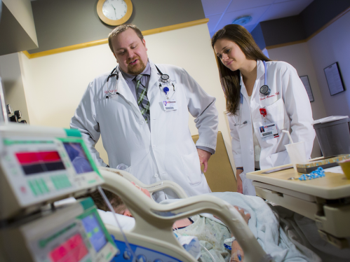 Family medicine physician Michael Noll and certified physician assistant Alexa Simon speak with a patient