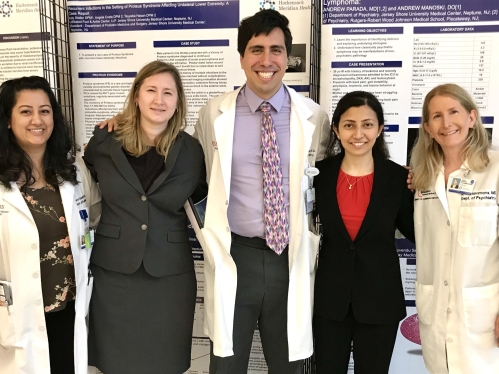 Psychiatry residents standing in front of their research poster presentations
