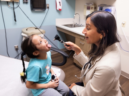 A doctor looks in a child's mouth in the clinic