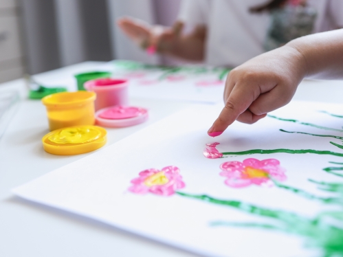 Children's hands finger painting on paper