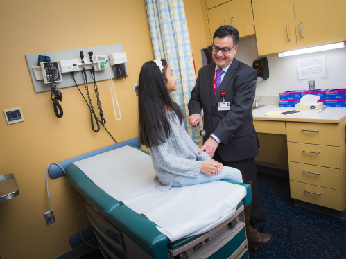 Pediatric Neurologist  Abdolreza Esfahanizadeh M.D. examines young female patient
