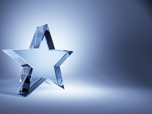Clear star award against blue background