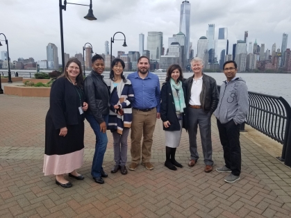A group of alumni fellows in Jersey City with New York skyline in the background