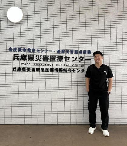 Jersey Chen stands in front of a sign at Hyogo Emergency Medical Center in Japan