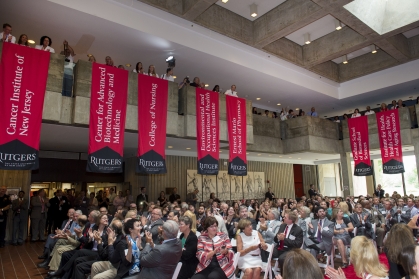 School and institute banners hang over the audience during the ceremony commemorating the Rutgers-UMDNJ integration on July 1, 2013.