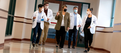 Dean Murtha and students walk down a corridor at the medical school