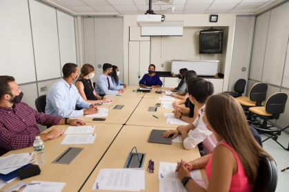 Students sit around a conference table in the medical school
