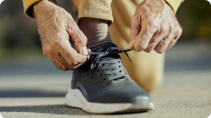 Image of older man tying his sneakers 
