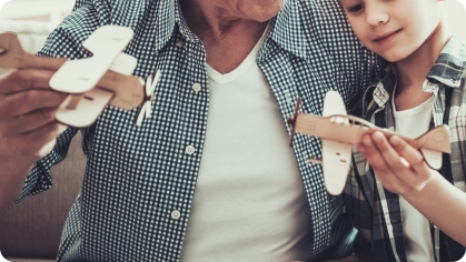 Image of father and son playing with model airplanes