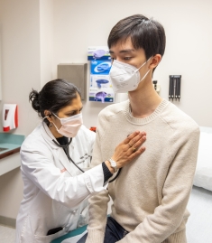 A doctor listens to a patient's heart with a stethoscope