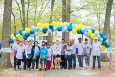 Volunteers posing under a balloon archway at a Cystic Fibrosis Fundraising Event