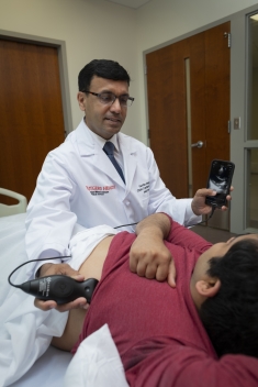 Dr. Sengupta uses pocket ultrasound to listen to a patient's heart