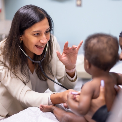 A doctor listens to an infant patient's heart
